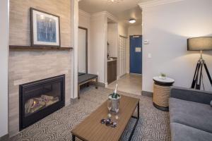 a living room with a fireplace and a couch at Aristocrat Hotel, BW Signature Collection in Half Moon Bay +10 photos