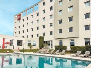ラ・ヴァレット・デュ・ヴァールにあるibis Toulon La Valetteの建物の前にプールがあるホテル