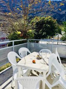 een witte tafel en witte stoelen op een balkon bij Ti case en l'air in Cilaos