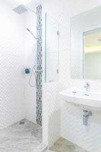 4M Pratunam Hotel في بانكوك: حمام أبيض مع دش ومغسلة