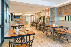 a restaurant with tables and chairs in a room at 4M Pratunam Hotel in Bangkok