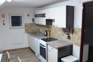 蒂什諾夫的住宿－75號公寓，厨房配有白色橱柜和炉灶烤箱。