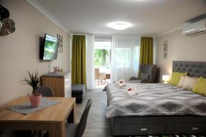 ドムボーバールにあるJudit Apartman Dombóvár-Gunarasのベッドルーム1室(ベッド1台、テーブル付)、ダイニングルームが備わります。