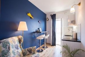a living room with a chair and a blue wall at Apartments Frenkie in Komiža