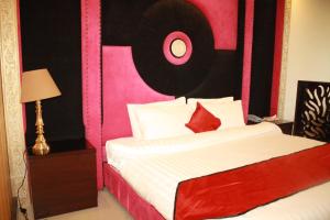 Schlafzimmer mit einem Bett mit einem rosa und schwarzen Kopfteil in der Unterkunft Shangrila Hotels and Resort in Murree