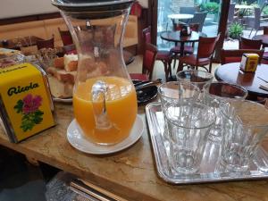 a jug of orange juice sitting on a table with glasses at Hotel I Narcisi in Siniscola