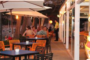a group of people sitting at tables in a restaurant at S'Arenal Apartments in Portinatx