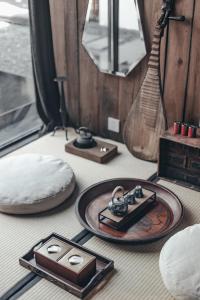 a room with a table with a plate and a guitar at Zhangjiajie Song Boutique B & B - Zhangjiajie National Forest Park Wulingyuan in Zhangjiajie