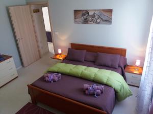 a bedroom with a bed with purple and green sheets at il glicine in Chieti