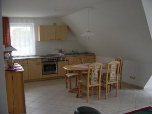 a kitchen with a table and chairs and a kitchen with a stove at Haus Galerie 1. OG in Karlshagen