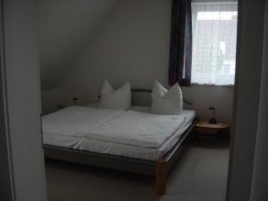 オストゼーバート・カールスハーゲンにあるHaus Galerie 1. OGのベッドルーム1室(白いシーツと枕のベッド1台付)