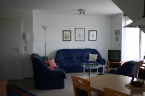 a living room with a blue couch and a table at Haus Galerie 1. OG in Karlshagen