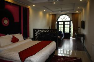 a hotel room with a bed and a window and a door at Shangrila Hotels and Resort in Murree