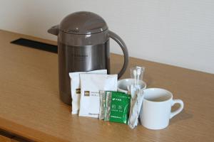 una cafetera y una taza de café sobre una mesa en Tachikawa Washington Hotel, en Tachikawa