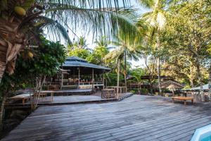 un paseo marítimo de madera con un restaurante con bancos y árboles en A-Na-Lay Resort Koh Kood en Ko Kood