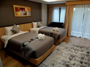 ハジャイにあるThe Raise Hotelのベッド2台とソファがあるホテルの部屋