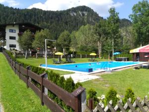 a swimming pool at a resort with a fence at Mittermooshof in Walchsee