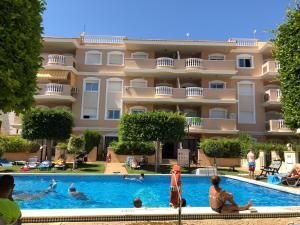 um hotel com piscina em frente a um edifício em Apartament Paula em Cabo Roig