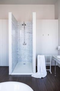 a bathroom with a shower with white walls and wood floors at B&B Dusk till dawn in Mechelen