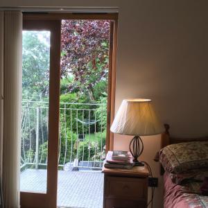 サンダースフットにあるThe Lavender Roomのベッドルーム1室(ランプ付きのバルコニーに面したドア付)