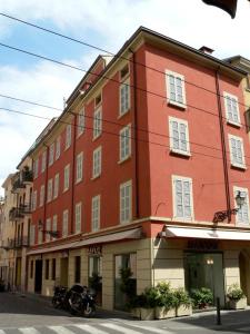 czerwony budynek z motocyklem zaparkowanym przed nim w obiekcie Savoy Hotel w mieście Parma
