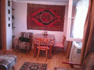 a dining room with a table and chairs and a rug at Бабушкин уют в РУСТАВИ in Rustavi