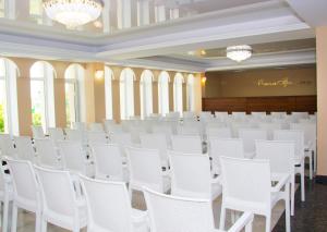 a row of white chairs in a room with windows at Hotel Promenad in Zatoka +82 photos