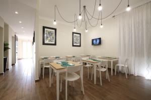 a dining room with white tables and white chairs at Khome Rooms & Apartment in Catania