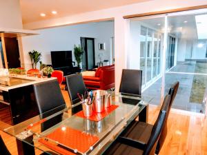 a living room with a glass table and chairs at Amore Miyakojima in Miyako-jima