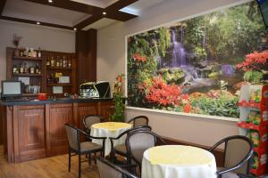 a restaurant with a large painting of a waterfall at Comfort Hotel in Fier
