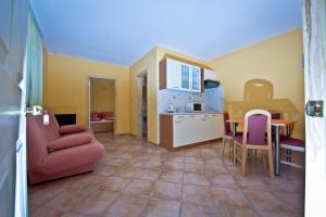 a living room with a red couch and a kitchen at Apartmani Ibolja in Promajna