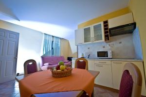 a kitchen with a table with a bowl of fruit on it at Apartmani Ibolja in Promajna +42 photos