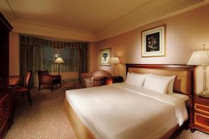 een hotelkamer met een groot bed en een woonkamer bij Rihga Royal Hotel Tokyo in Tokyo