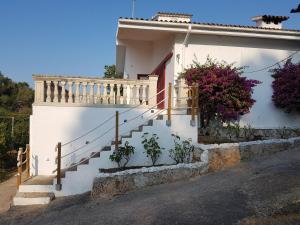 Una casa blanca con escaleras y flores. en Finca Sa Cova de Mallorca en Sencelles