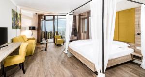 a hotel room with a bed and a desk and chair at Hotel Plattenhof in Termeno +39 photos