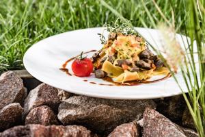 a plate of food sitting on a pile of rocks at Hotel Plattenhof in Termeno