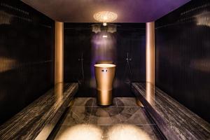 a bathroom with a toilet in a dark room at Hotel Plattenhof in Termeno