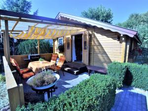 a backyard patio with a table and chairs and a pergola at Bungalow in Klein Str mkendorf in Klein Strömkendorf