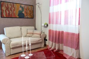 uma sala de estar com um sofá e uma mesa de vidro em La Finestra sul Borgo em Alba