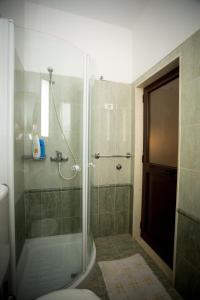 baño con ducha y puerta de cristal en Kolping, en Shkodër