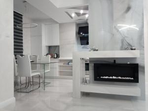 a white kitchen with a fireplace and a dining table at N&L in Banja Luka