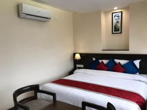 a bedroom with a bed with red and blue pillows at Kaveri Inn in Kathmandu