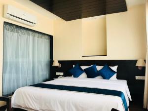 a bedroom with a large bed with blue pillows at Kaveri Inn in Kathmandu