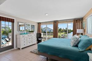 a bedroom with a bed and a balcony at Latitude 26 Waterfront Boutique Resort - Bonita Springs in Bonita Springs