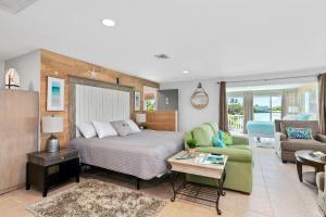 a bedroom with a bed and a living room at Latitude 26 Waterfront Boutique Resort - Bonita Springs in Bonita Springs