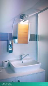ein Badezimmer mit einem weißen Waschbecken und einem Spiegel in der Unterkunft House Korina B&B in Ličko Petrovo Selo