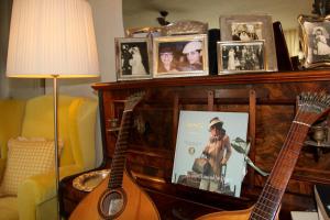 a living room with a guitar and pictures on a fireplace at Carmo's Boutique Hotel - Small Luxury Hotels of the World in Ponte de Lima