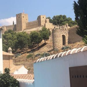 un château au sommet d'une colline plantée d'arbres dans l'établissement Casa Rural Antikaria, à Antequera
