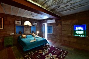 1 dormitorio con 1 cama y TV. en The Arch Boutique Home stay, en Jodhpur