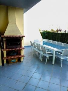 a patio with a table and chairs and a fireplace at Meia Praia Terrace in Lagos